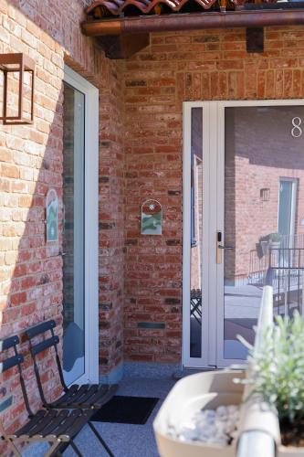 a patio door with a bench next to a brick wall at RESPIRA - rooms & apartments in Serralunga d'Alba