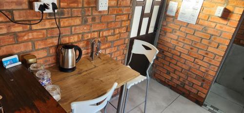 a wooden table and chairs next to a brick wall at LyonsDen 1 in Worcester