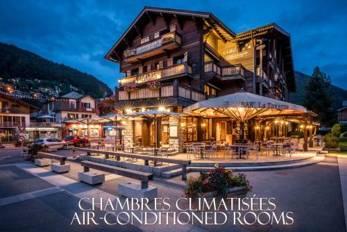 a building with tables and chairs in front of it at Hotel Le Samoyede in Morzine