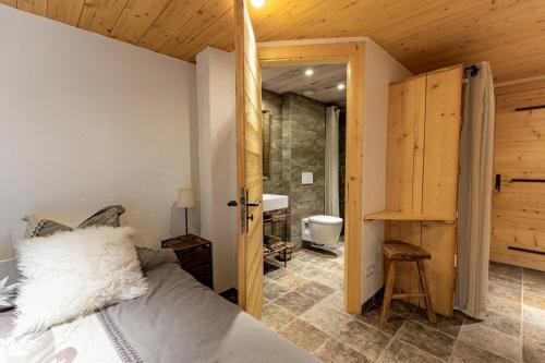 a bedroom with a bed and a bathroom at La Grange de Véro in Habère-Poche