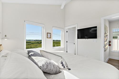 a white bedroom with a large bed and two windows at St. Francis Inn - Saint Augustine in Saint Augustine