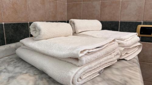 a pile of white towels sitting on a counter in a bathroom at B&b Ophelia in Otranto