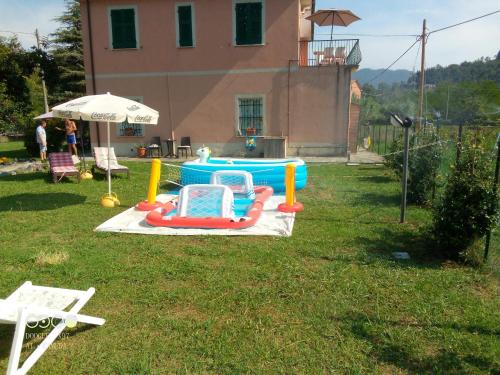 a pool in a yard with two chairs and an umbrella at Il Rio Grande in Beverino