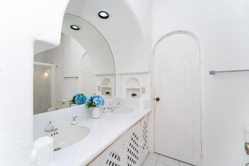 a white bathroom with two sinks and a mirror at 3067 - Casa Blanca in Tangolunda