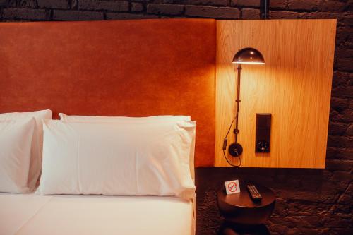 a bedroom with a bed and a lamp and a remote control at Hotel Transit in Barcelona
