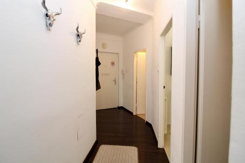 a hallway of a house with white walls and wood floors at Balcony Apartment - Next to Opera in Vienna