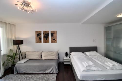 a bedroom with two beds and a chandelier at Balcony Apartment - Next to Opera in Vienna
