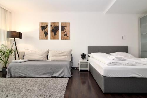 two beds in a room with white walls at Balcony Apartment - Next to Opera in Vienna