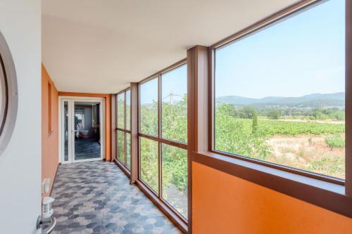 a hallway with large windows with a view at Le Mas du Lingousto in Cuers