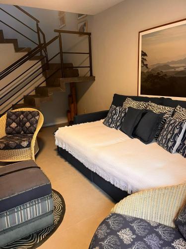 a bedroom with two beds and a stair case at Casa aconchegante in Maresias