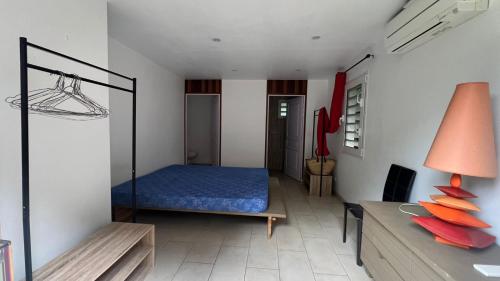 a bedroom with a blue bed in a room at Chambre villa la mahaudiere in Îlet à Christophe