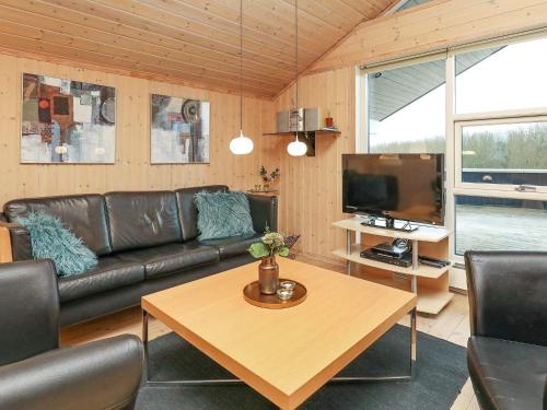 a living room with a leather couch and a table at 6 person holiday home in Ringkøbing-By Traum in Søndervig