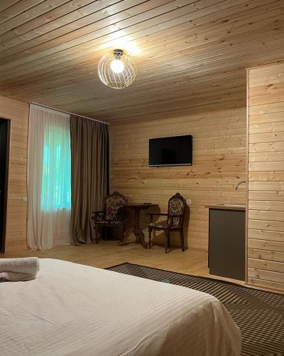 a bedroom with a bed and a flat screen tv at Ateni Hills in Gori