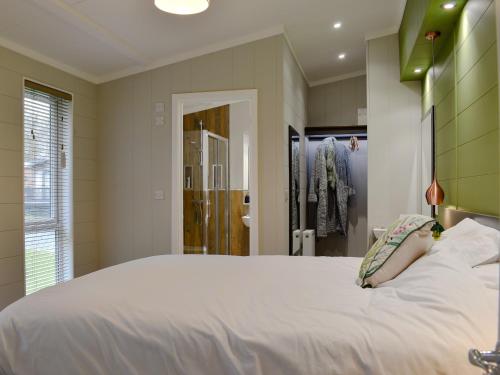 a bedroom with a large white bed and a shower at Lakeview Lodge in Landford