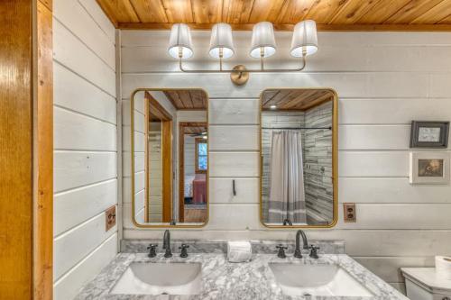 a bathroom with two sinks and two mirrors at Eagles Haven - Two Cabins with Massive Deck & Views in Blue Ridge
