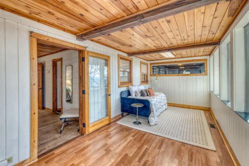 a living room with a blue couch and wooden ceilings at Eagles Haven - Two Cabins with Massive Deck & Views in Blue Ridge