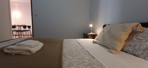 a bedroom with a bed with towels on it at Casa da Praia - Beach of Sand and Sea at the Door in Vila Praia de Âncora