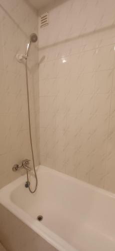 a white bath tub with a shower in a bathroom at Casa da Praia - Beach of Sand and Sea at the Door in Vila Praia de Âncora