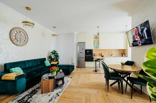a living room with a green couch and a table at Arinis Best Bucovina Apartament in Gura Humorului