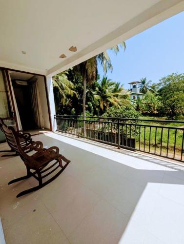 a porch with two chairs on a balcony at Villa Lovi Tree in Katunayake