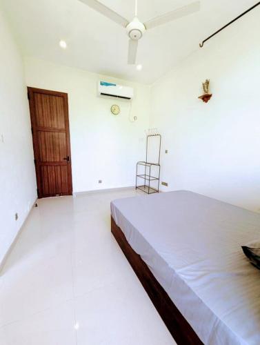 a white room with a bed and a chair in it at Villa Lovi Tree in Katunayake