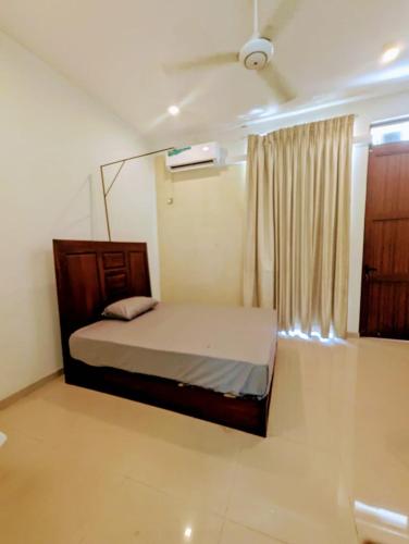a small bedroom with a bed and a window at Villa Lovi Tree in Katunayake