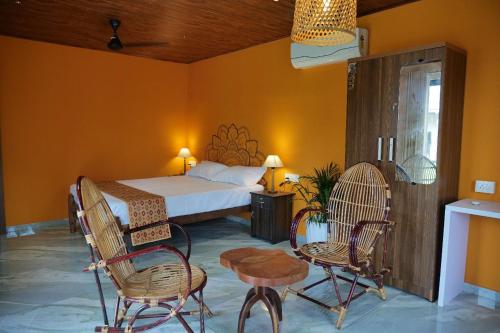 a bedroom with a bed and two chairs and a table at Kalinga kayaloram in Turavūr