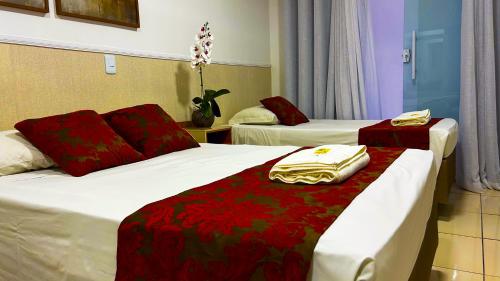a hotel room with two beds with red sheets at Max Hotel in Brasilia