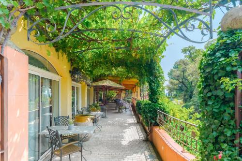 an arched walkway with tables and chairs on a building at Le Mas du Lingousto in Cuers