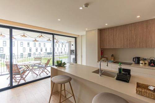 a kitchen with a counter and a view of a patio at GuestReady - Elegant beachside stay in Apúlia in Apúlia