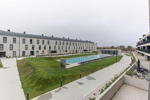 a large building with a swimming pool in front of it at GuestReady - Elegant beachside stay in Apúlia in Apúlia