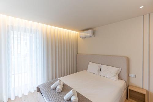 a bedroom with a bed with two white towels on it at GuestReady - Elegant beachside stay in Apúlia in Apúlia