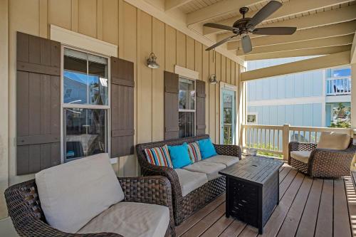 a porch with wicker furniture and a ceiling fan at Steps to Pool & Beach on Magical in Santa Rosa Beach