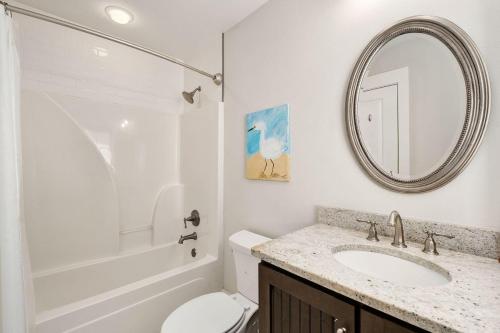 a bathroom with a sink and a toilet and a mirror at Steps to Pool & Beach on Magical in Santa Rosa Beach