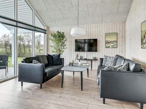 a living room with two couches and a table at 14 person holiday home in Idestrup in Marielyst
