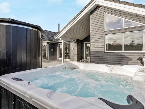 a hot tub in front of a house at 14 person holiday home in Idestrup in Marielyst