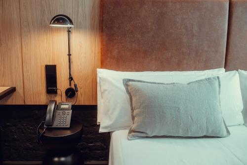 a bedroom with a bed with a phone and a lamp at Hotel Transit in Barcelona