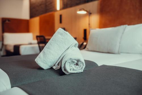 a towel on a bed in a hotel room at Hotel Transit in Barcelona