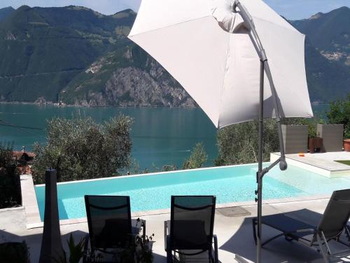 a white umbrella sitting next to a swimming pool at Marone Apartment with Pool in Marone