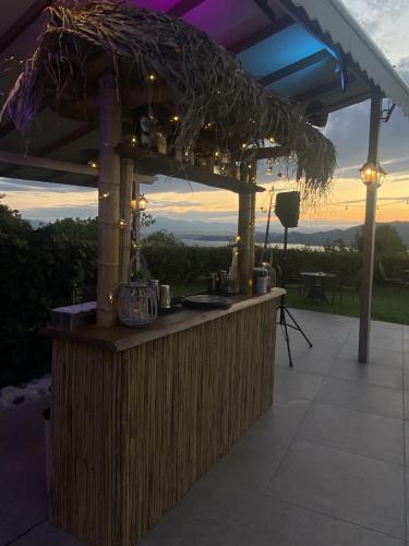 a bar under a roof with a sunset in the background at Agnanti Hotel in Velventós