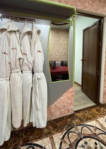a mirror in a room with white robes at Edem Hotel in Elar