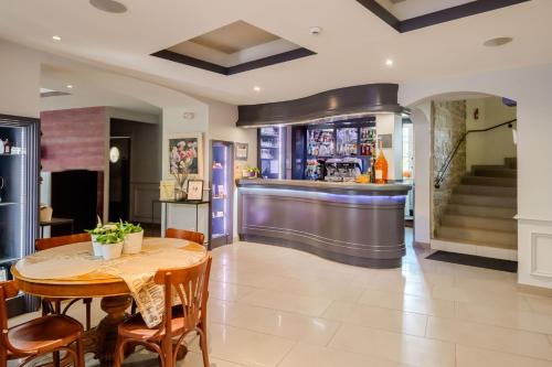a dining room with a table and a bar at Le Mas du Lingousto in Cuers