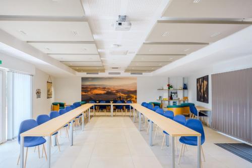 a conference room with tables and blue chairs at Le Mas du Lingousto in Cuers