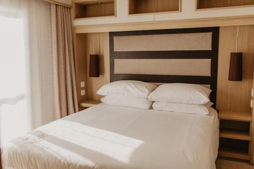 ein Schlafzimmer mit einem Bett mit weißen Laken und Kissen in der Unterkunft Lower Cliff 8 in Portland