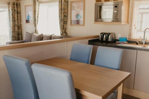 a kitchen with a wooden table and blue chairs at Lower Cliff 8 in Portland