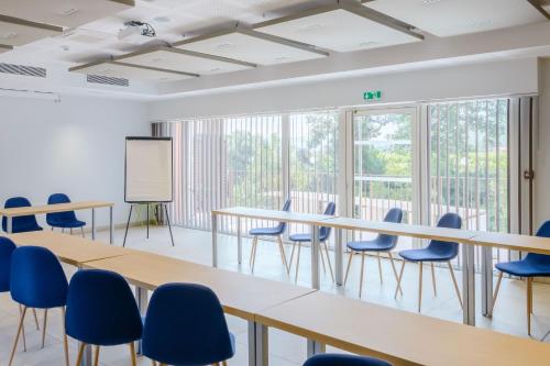 a conference room with tables and chairs and a whiteboard at Le Mas du Lingousto in Cuers