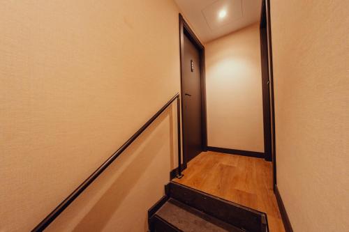 a hallway with a stairway leading to a door at Hotel Transit in Barcelona