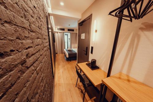 a room with a table and a stone wall at Hotel Transit in Barcelona
