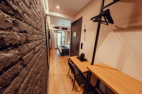 a room with a table and a stone wall at Hotel Transit in Barcelona