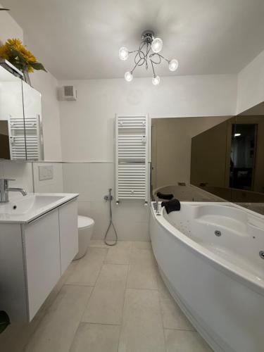 un bagno con vasca, lavandino e WC di Orchidea Apartment a Breuil-Cervinia